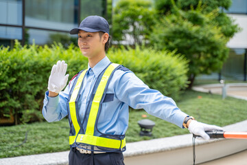誘導棒を持って交通誘導をするガードマン男性