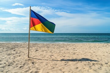 Colorful flag waving on beach with blue sky and ocean