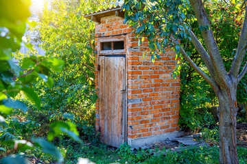 Brick toilet outdoors in a green garden