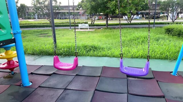 Smooth swinging motion of a wooden swing in a peaceful park, captured in 4K with natural sunlight filtering through trees. Perfect for relaxation, meditation, or background visuals