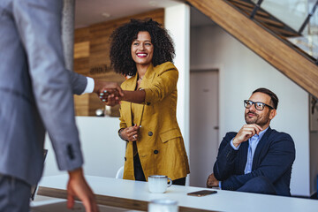Professional Business Meeting With Confident Handshake and Smiling Colleagues