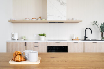 Kitchen counter with coffee cups and french croissants