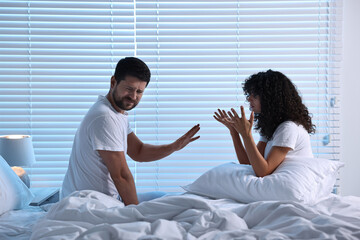 Obraz premium Emotional couple arguing in bedroom at night. Relationship problems