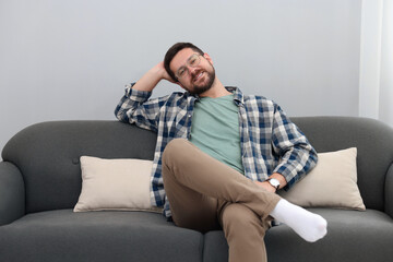 Obraz premium Smiling man relaxing on sofa at home