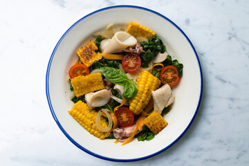 Mediterranean corn salad with squid. Top view table with  decorations.
