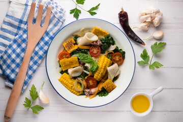 Mediterranean corn salad with squid. Top view table with  decorations.