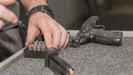 Man loads ammunition into a gun at a shooting range