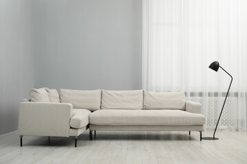 Stylish room interior with comfortable sofa and lamp