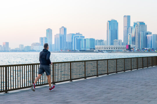 man running along seafront in morning. healthy lifestyle, sport in city