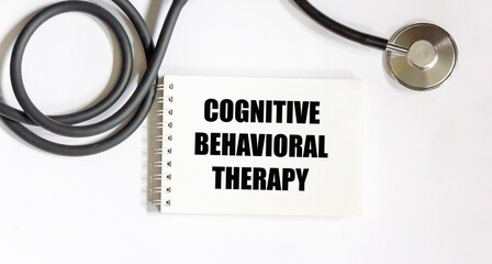 Stescoscope with COGNITIVE BEHAVIORAL THERAPY notepad on white background.