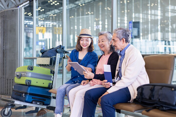 Group of Asian family tourist passengers with senior is using mobile application to call pick up...