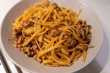 A bowl of linguine with meat.