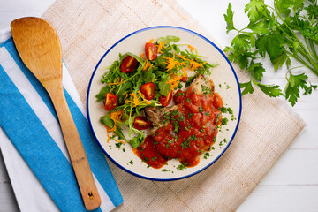 Pork chops with tomato sauce and salad. Top view table with decorations.