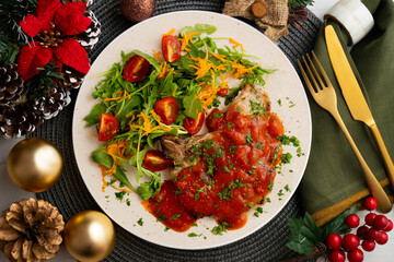 Pork chops with tomato sauce and salad. Top view table with Christmas decorations.