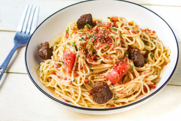 close-up of spaghetti dish with toppings and meat on table