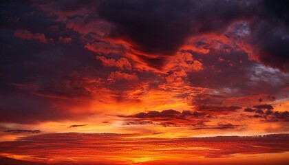 A vivid red sunset paints the evening sky with drama, its fiery hues mingling with billowing clouds. This fantastical backdrop offers space for creative design, evoking themes