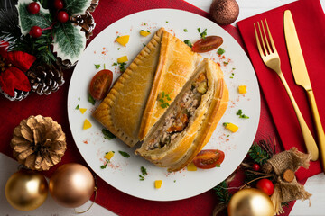 Galician empanada with vegetables and fish. Top view table with Christmas decorations.