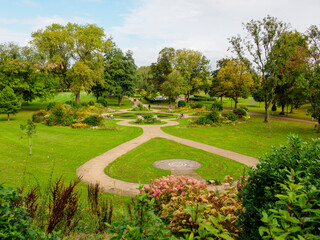 Salford, Peel park. Beautiful garden park with winding pathways, lush greenery, and vibrant flowers.