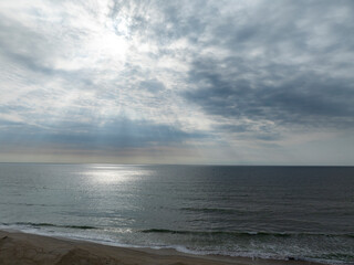 Looking at the ocean as the sun peeks through the clouds.