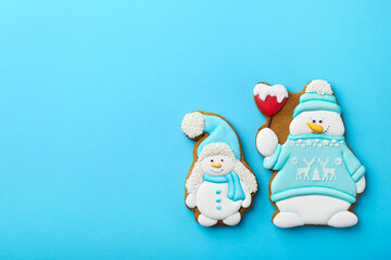 Tasty Christmas cookies in shape of snowman on light blue background, flat lay. Space for text