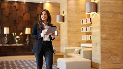 Young, ambitious businesswoman using tablet on the move