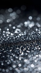 Fototapeta premium A close-up of silver glitter, scattered on a black background, with a shallow depth of field