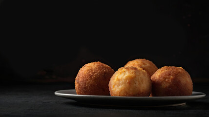 Traditional Italian Arancini Fried Rice Balls with Blank Space on Black Background.