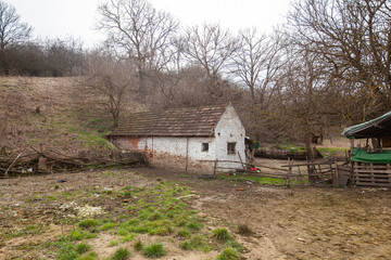  Lonely farmhouse in a rural area surrounded by bare trees and fields during the winter season.