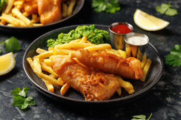 British Fish and chips with mashed peas, tartar and ketchup sauce.