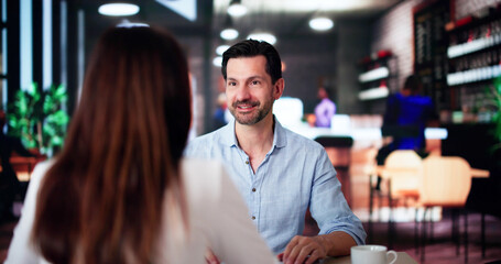 Laughing Male And Female Sitting In Cafe Drinking Coffee