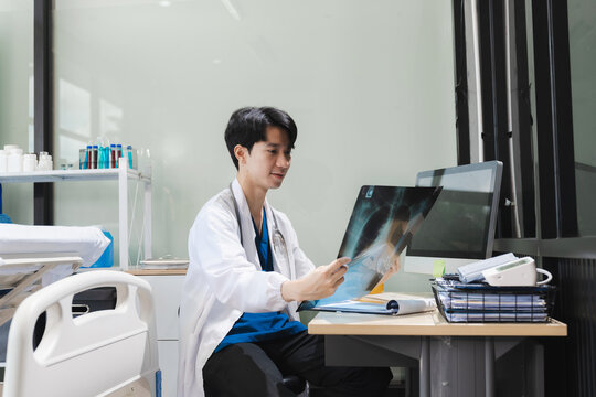 Doctor working on laptop computer and tablet and x-ray film analyzed the results, electronics medical record system EMRs concept.