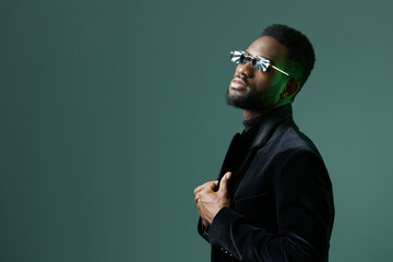 Confident businessman in stylish suit and sunglasses expressing selfassurance against a vibrant green backdrop