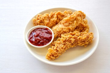 Crispy Fried chicken strips or Fried Boneless Chicken with tomato sauce  in  white plate  on white background 