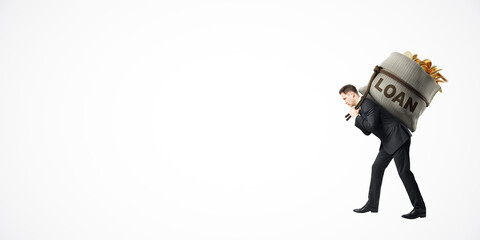 Businessman carrying large sack labeled LOAN on his back, white background.