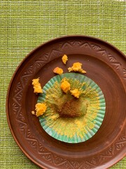 Leftovers on a clay plate. Pumpkin muffin crumbs with wrapper on a plate