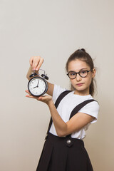 girl schoolgirl with an alarm clock her hands