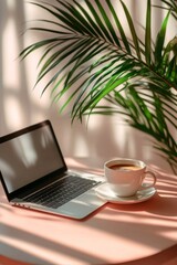 Fototapeta premium Laptop and cup of coffee on table with houseplant shadow, cozy work atmosphere