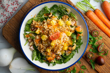Healthy rice, pineapple and turkey salad. Top view table with  decorations.