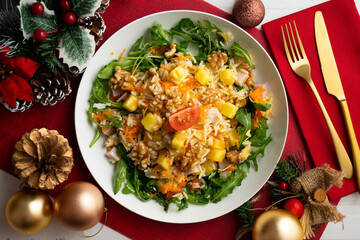 Healthy rice, pineapple and turkey salad. Top view table with Christmas decorations.