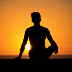 Silhouette of man sitting in meditation pose during sunset