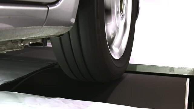 Close-up view of car wheel in blur motion during rolling resistant test, measure dynamic interaction between tire and roller surface during speed testing in lab