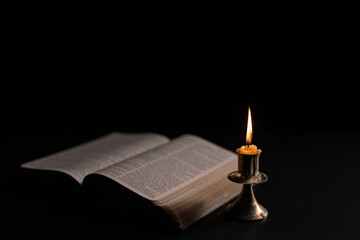 Dark, an antique candle cast its light on the old Bible, its flames flickering gently over the book...