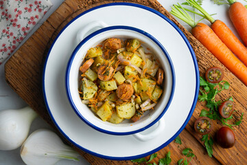 Healthy potato, onion and sausage salad. Top view table with decorations.