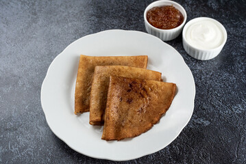 Homemade Crepes with Sour Cream and Jam on a Plate