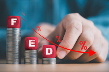 Businessman putting FED wording with down arrow and percentage sign for Federal reserve of USA...