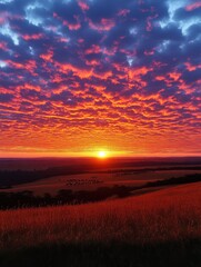 Awe-inspiring countryside sunset with vibrant orange and red sky casting a warm glow over rolling hills and fields at dusk