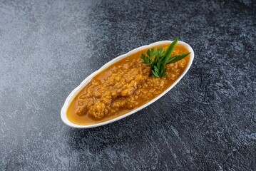 A bowl of food with a green herb on top
