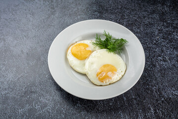 Two eggs with a yellow yolk on a white plate