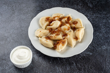 A plate of dumplings with a white sauce on the side