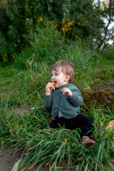 A boy on the shore in the green grass has a picnic